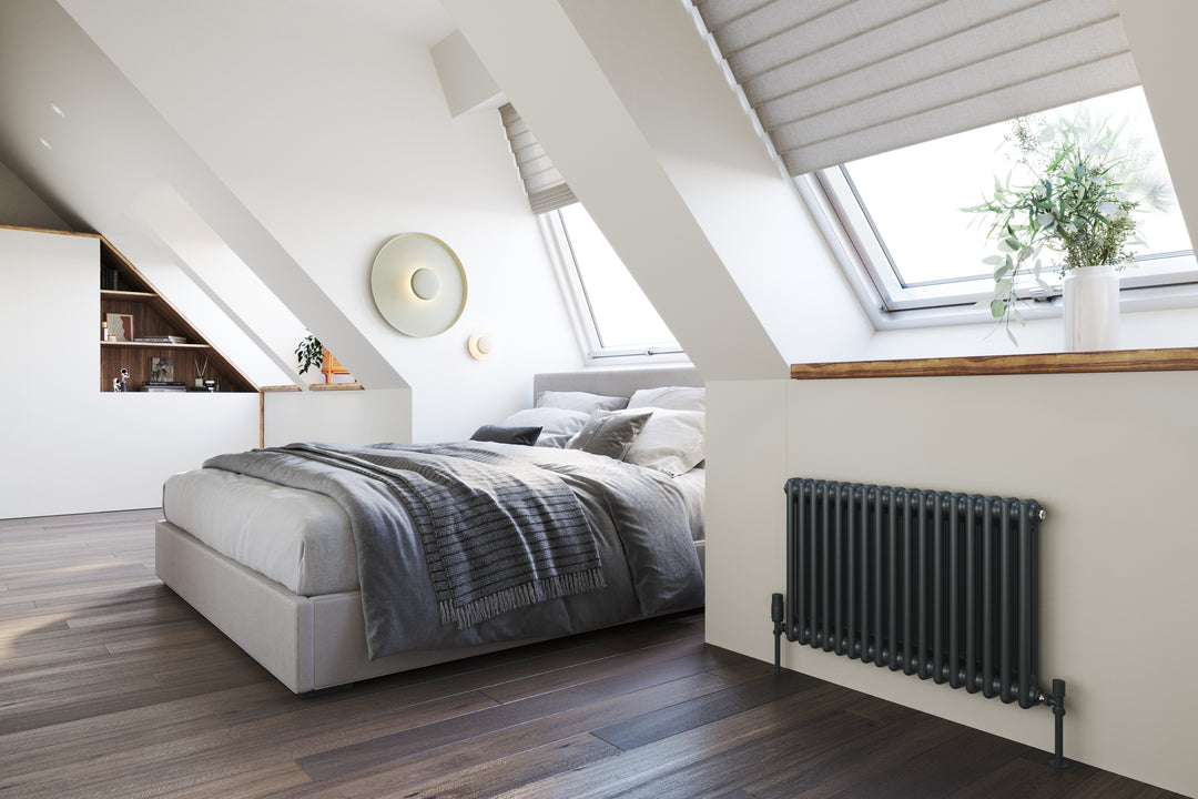 An image of a dormer loft room with a grey radiator placed underneath a window