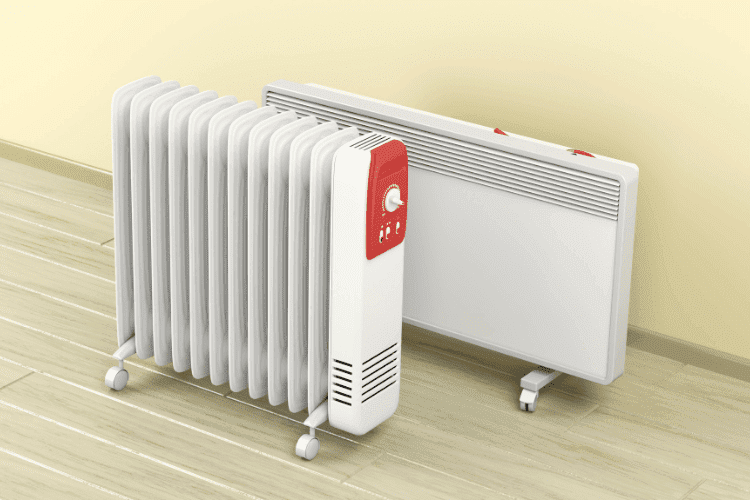 Two portable electric heaters, one oil-filled and one panel-style, placed on a wooden floor near a wall.