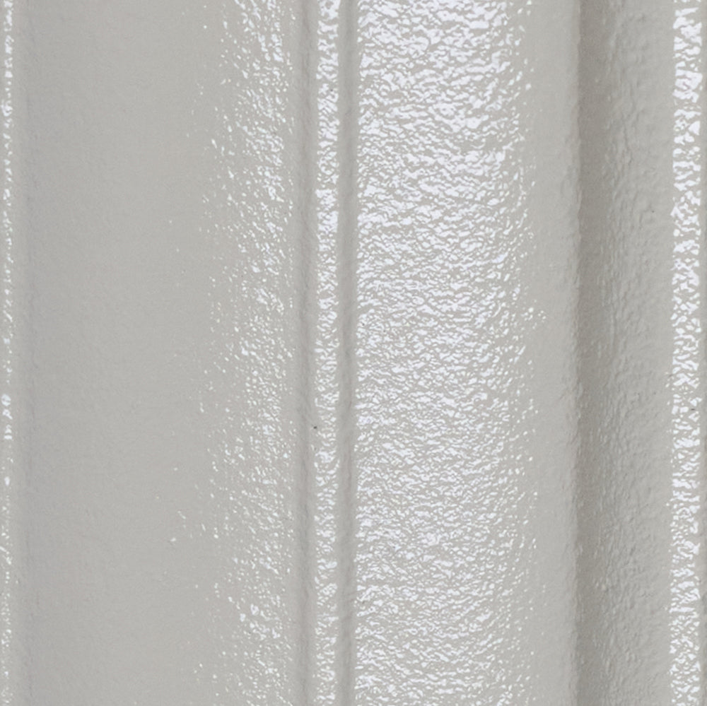 Close-up of the Pebble Grey cast iron radiator finish on a curved column surface.