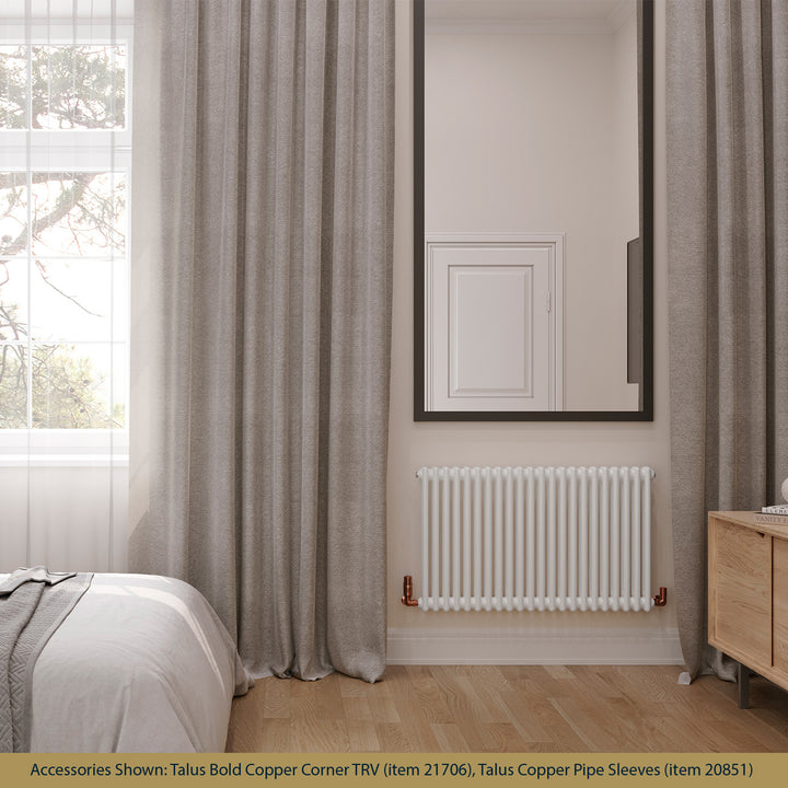 Alpha white 2-column radiator, H600mm x W988mm, between floor-length grey curtains in a softly furnished bedroom.