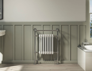 Traditional white towel rail on an olive coloured wall with a bath to the right